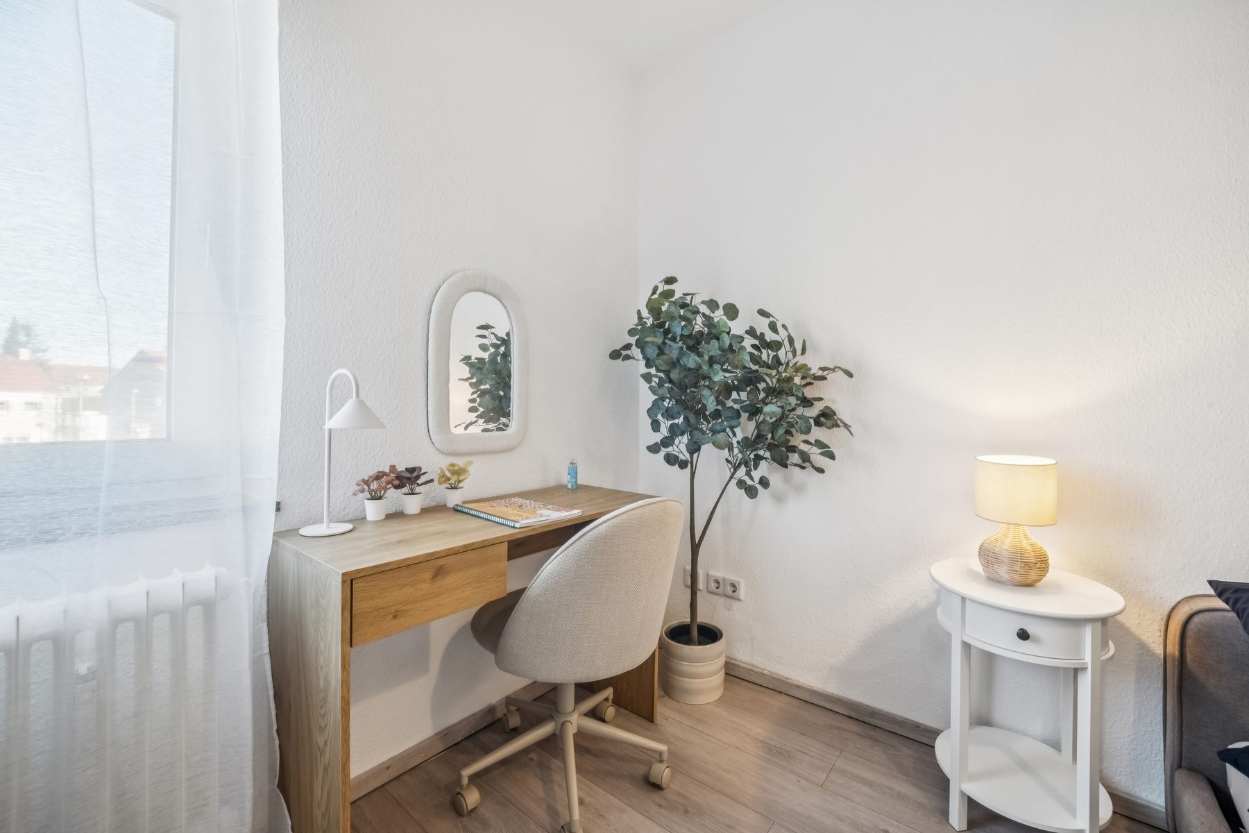 Schreibtisch am Fenster mit Stuhl und Leuchte