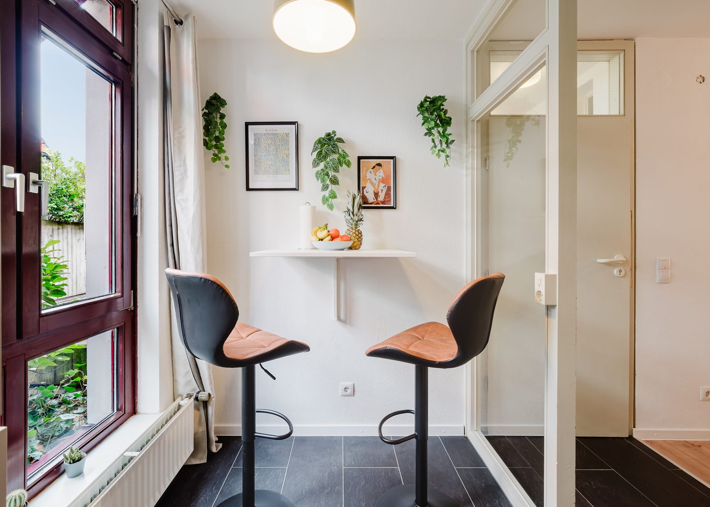 Theke mit zwei Barhockern am Fenster des Kirchenblick-Lofts