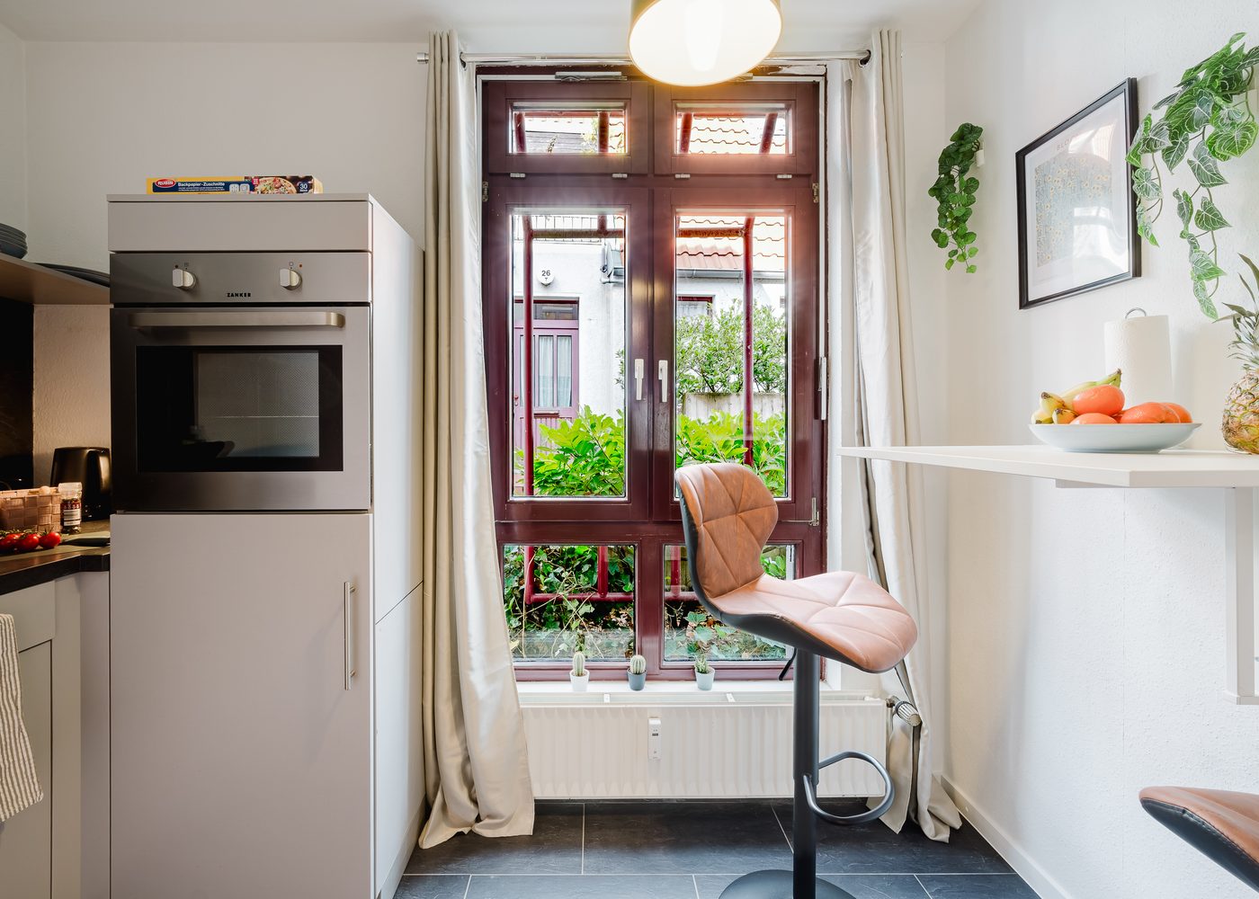 Küche des Kirchenblick-Lofts mit Backofen, Mikrowelle und Fenster zum Innenhof