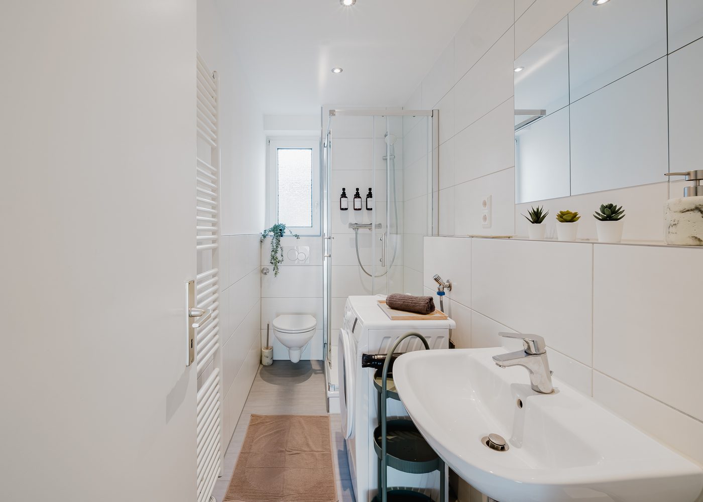 Badezimmer des Stadtjuwels mit Dusche, Waschbecken und Handtuchheizkörper