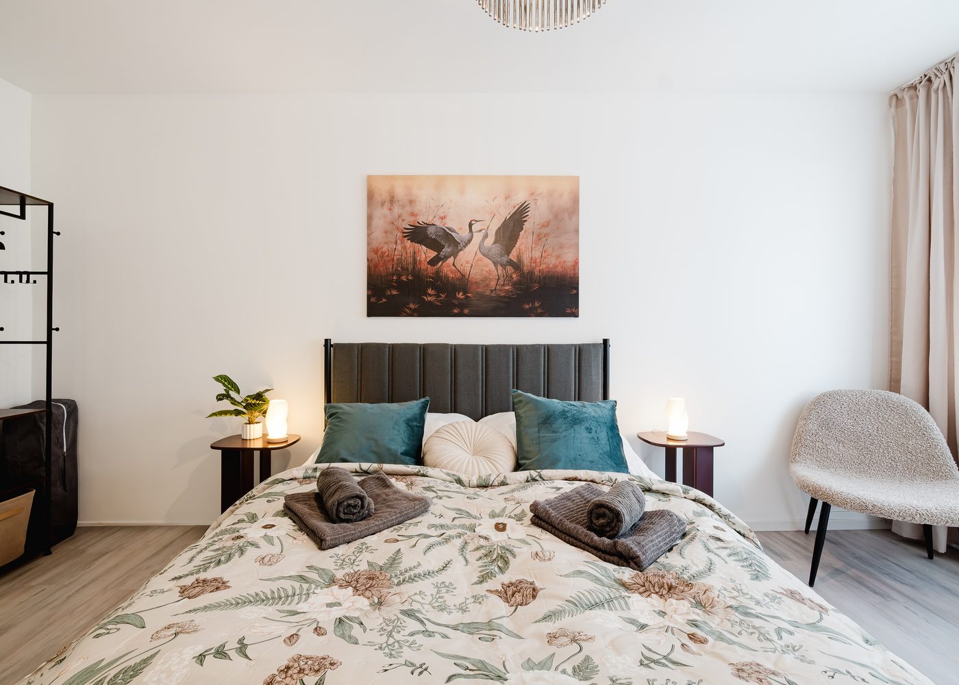 Schlafzimmer des Stadtjuwels mit Doppelbett, gepolstertem Kopfteil und Sessel
